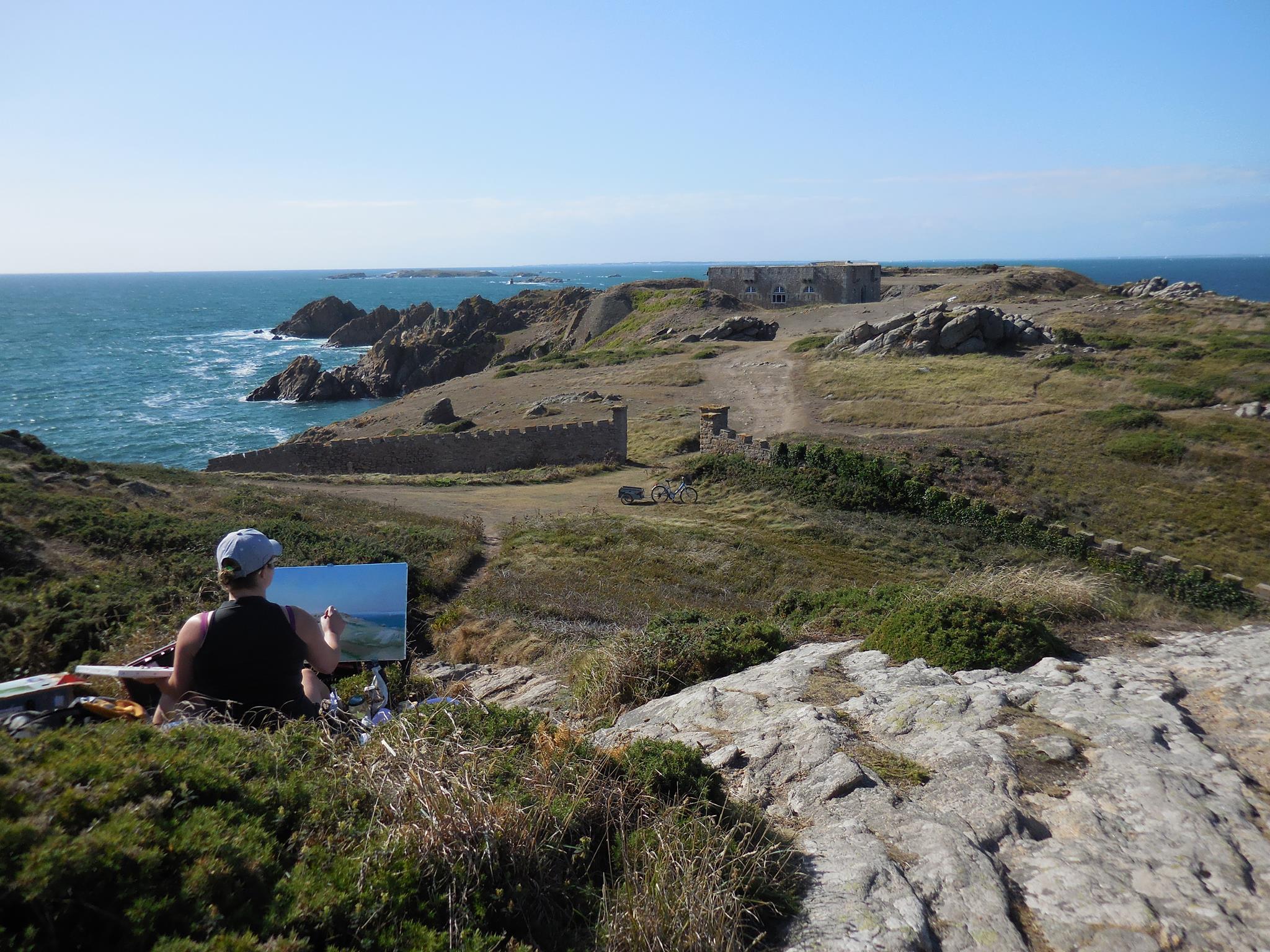 Artiste peignant face au paysage marin